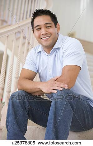 Stock Photography - Man sitting on staircase smiling. Fotosearch