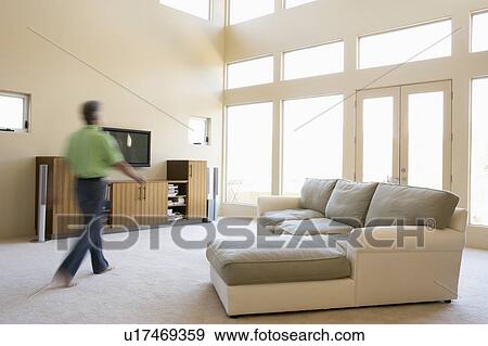 Man walking through living room View Large Photo Image Stock Photo - Man walking through living room. Fotosearch