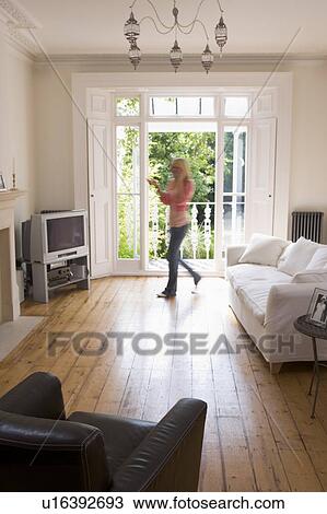 Stock Image - Woman in living room talking on telephone. Fotosearch