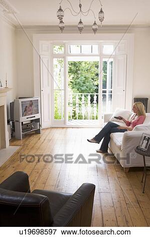 Woman in living room watching television View Large Photo Image Stock Photo - Woman in living room watching television. Fotosearch