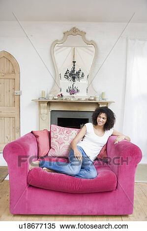 Woman sitting in living room smiling View Large Photo Image Stock Photography - Woman sitting in living room smiling. Fotosearch
