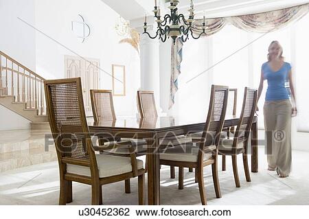 Woman walking in dining room View Large Photo Image Stock Image - Woman walking in dining room. Fotosearch