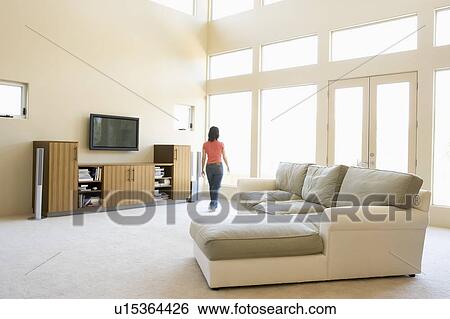 Stock Photograph - Woman walking through living room. Fotosearch