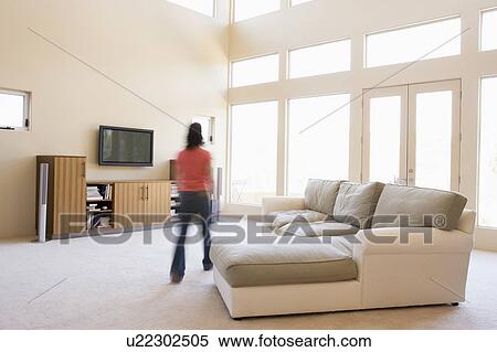 Woman walking through living room View Large Photo Image Stock Photography - Woman walking through living room. Fotosearch