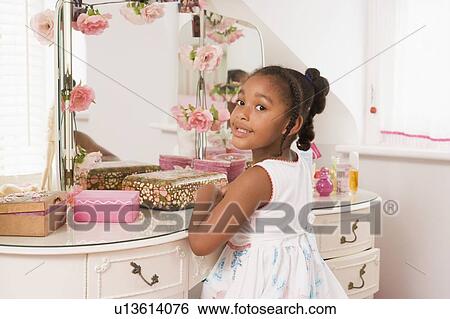 Young girl sitting at mirror in bedroom smiling View Large Photo Image Stock Photograph - Young girl sitting at mirror in bedroom smiling. Fotosearch