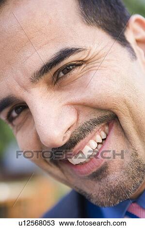 Stock Image - Businessman's smiling face outdoors (selective focus). Fotosearch