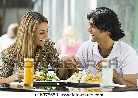 Couple at restaurant eating and smiling (selective focus) View Large Photo Image Stock Image - Couple at restaurant eating and smiling (selective focus). Fotosearch