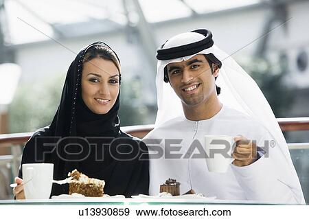 Couple at restaurant eating dessert and smiling (selective focus) View Large Photo Image Stock Photo - Couple at restaurant eating dessert and smiling (selective focus). Fotosearch