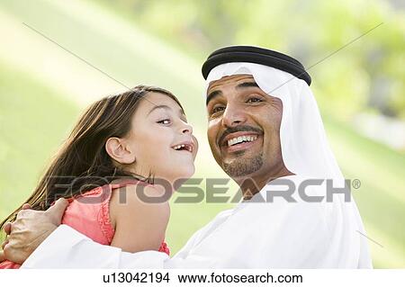 Man and young girl outdoors in park playing and smiling (selective focus) View Large Photo Image Picture - Man and young girl outdoors in park playing and smiling (selective focus). Fotosearch