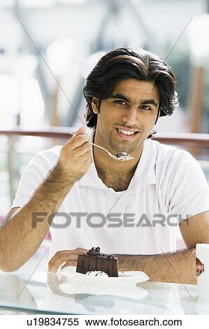 Man at restaurant eating dessert and smiling (selective focus) View Large Photo Image Stock Photography - Man at restaurant eating dessert and smiling (selective focus). Fotosearch