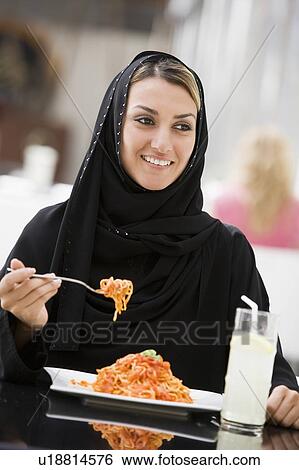 Woman at restaurant eating spaghetti and smiling (selective focus) View Large Photo Image Stock Photograph - Woman at restaurant eating spaghetti and smiling (selective focus). Fotosearch