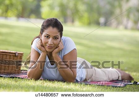 Woman lying outdoors at park with picnic basket smiling (selective focus) View Large Photo Image Stock Photo - Woman lying outdoors at park with picnic basket smiling (selective focus). Fotosearch