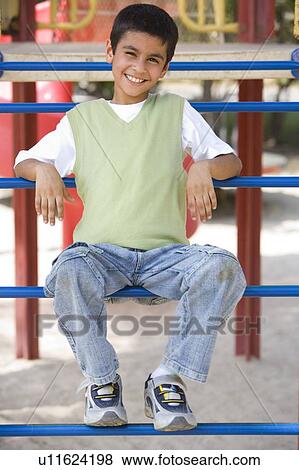 Young boy on playground structure smiling (selective focus) View Large Photo Image Stock Photo - Young boy on playground structure smiling (selective focus). Fotosearch