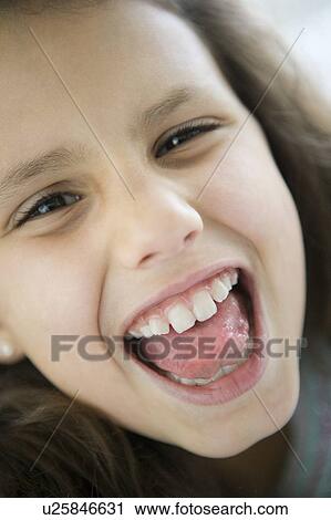 Stock Image - Young girl indoors shouting and smiling (high key). Fotosearch
