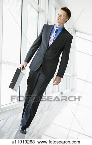 Businessman walking in corridor View Large Photo Image Stock Photo - Businessman walking in corridor. Fotosearch