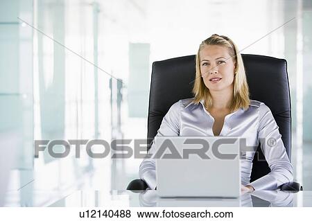 Stock Photo - Businesswoman in office with a laptop. Fotosearch