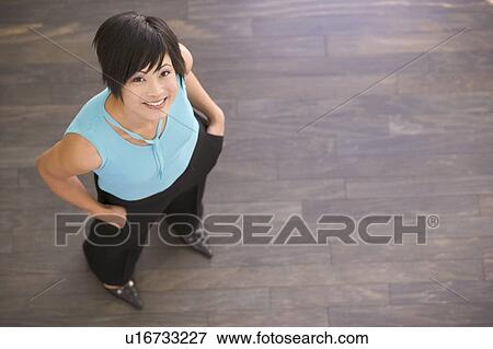 Stock Photo - Businesswoman standing indoors smiling. Fotosearch
