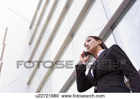 Businesswoman standing outdoors by building on cellular phone (high key/selective focus) View Large Photo Image Stock Image - Businesswoman standing outdoors by building on cellular phone (high key/selective focus). Fotosearch