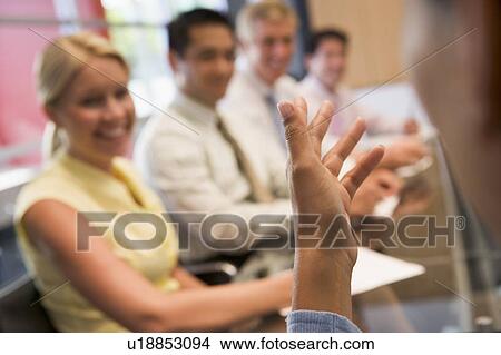Five businesspeople at boardroom table with focus on businessman's hand View Large Photo Image Picture - Five businesspeople at boardroom table with focus on businessman's hand. Fotosearch