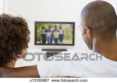 Stock Photo - Couple in living room watching television. Fotosearch