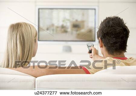 Stock Photo - Couple in living room watching television. Fotosearch