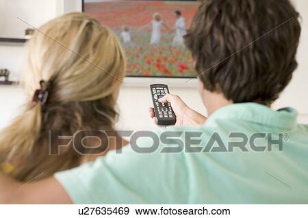 Couple in living room watching television View Large Photo Image Stock Photo - Couple in living room watching television. Fotosearch