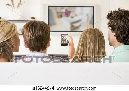 Family in living room with remote control and flat screen television View Large Photo Image Picture - Family in living room with remote control and flat screen television. Fotosearch