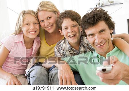 Family in living room with remote control smiling View Large Photo Image Stock Image - Family in living room with remote control smiling. Fotosearch