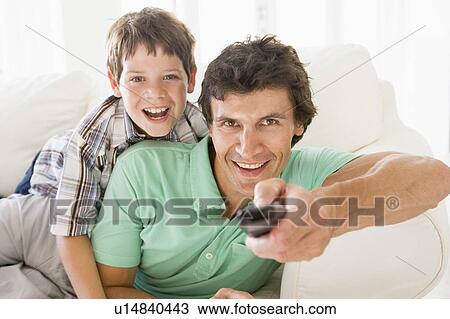 Stock Image - Man and young boy with remote control smiling. Fotosearch