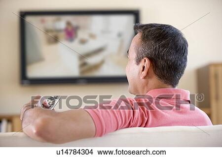 Man in living room watching television View Large Photo Image Picture - Man in living room watching television. Fotosearch