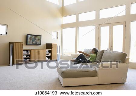 Man in living room watching television View Large Photo Image Stock Image - Man in living room watching television. Fotosearch