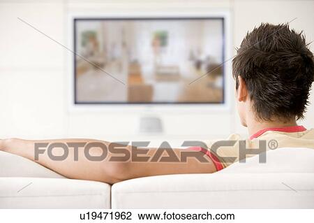 Man in living room watching television View Large Photo Image Stock Image - Man in living room watching television. Fotosearch