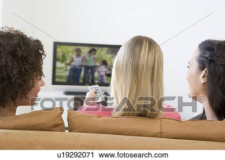 Three women in living room watching television View Large Photo Image Stock Image - Three women in living room watching television. Fotosearch
