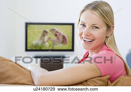 Woman in living room watching television smiling View Large Photo Image Stock Photo - Woman in living room watching television smiling. Fotosearch
