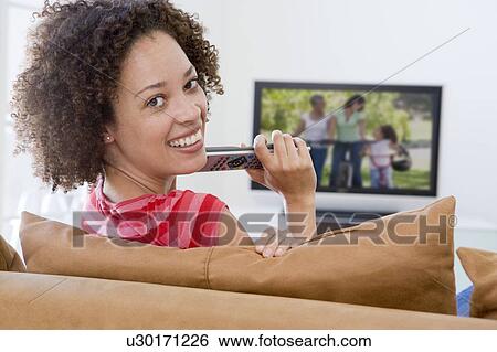 Woman in living room watching television View Large Photo Image Stock Photograph - Woman in living room watching television. Fotosearch