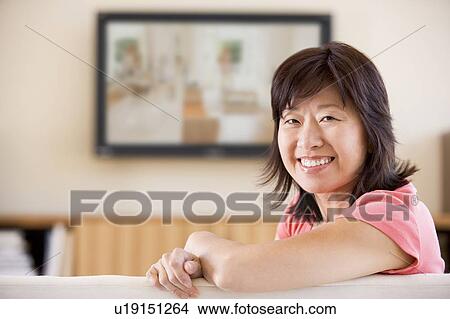 Woman watching television smiling View Large Photo Image Picture - Woman watching television smiling. Fotosearch