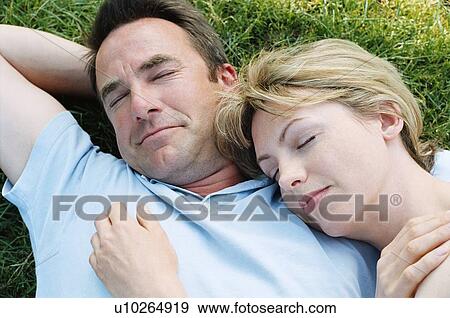 Stock Photo - Couple lying outdoors sleeping. Fotosearch