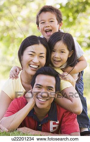 Family lying outdoors smiling View Large Photo Image Picture - Family lying outdoors smiling. Fotosearch