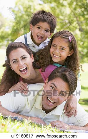 Family lying outdoors smiling View Large Photo Image Stock Photo - Family lying outdoors smiling. Fotosearch