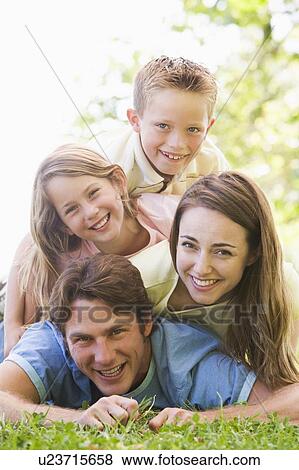 Family lying outdoors smiling View Large Photo Image Stock Photo - Family lying outdoors smiling. Fotosearch