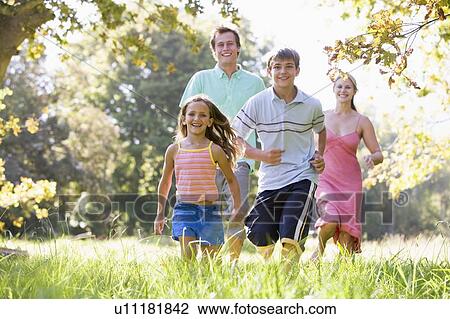 Stock Image - Family running outdoors smiling. Fotosearch