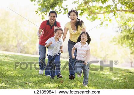 Stock Image - Family running outdoors smiling. Fotosearch