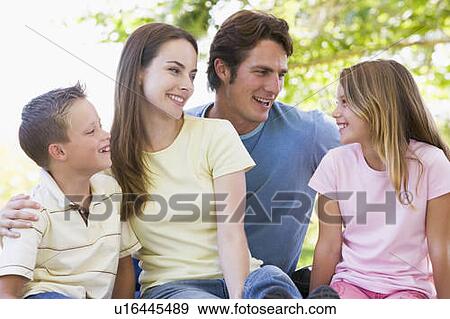 Stock Photo - Family sitting outdoors smiling. Fotosearch