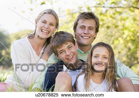 Stock Photography - Family sitting outdoors smiling. Fotosearch