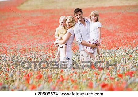 Picture - Family standing in poppy field smiling. Fotosearch