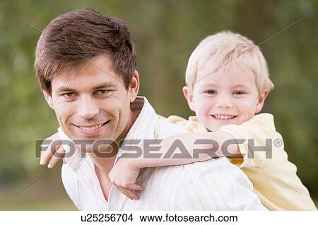 Father holding son outdoors smiling View Large Photo Image Picture - Father holding son outdoors smiling. Fotosearch