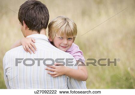 Father holding son outdoors smiling View Large Photo Image Stock Image - Father holding son outdoors smiling. Fotosearch