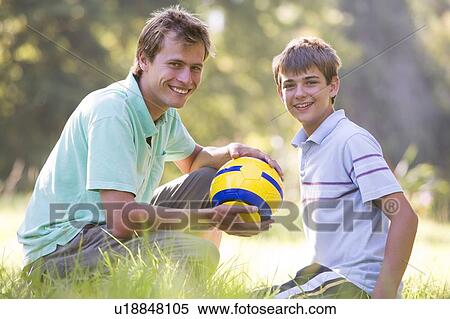 Man and young boy outdoors with soccer ball smiling View Large Photo Image Stock Photography - Man and young boy outdoors with soccer ball smiling. Fotosearch