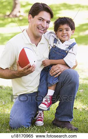 Man and young boy outdoors with football smiling View Large Photo Image Stock Photography - Man and young boy outdoors with football smiling. Fotosearch