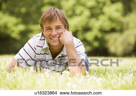 Man lying outdoors smiling View Large Photo Image Picture - Man lying outdoors smiling. Fotosearch